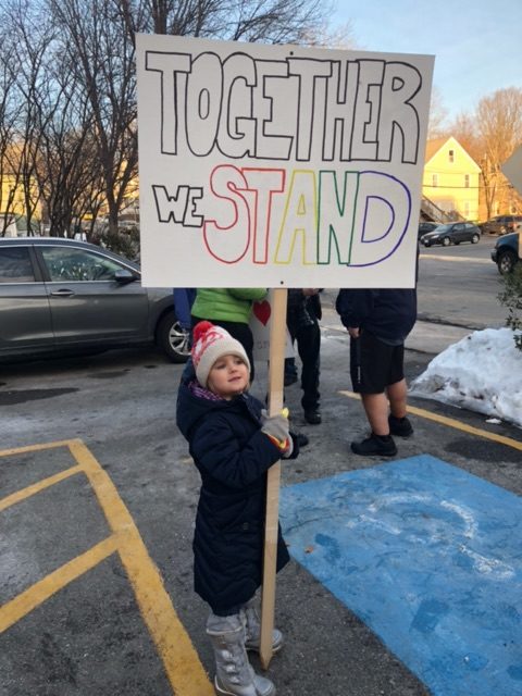 Lori's daughter holds a sign that reads "Together we stand" at the 2018 Women's March